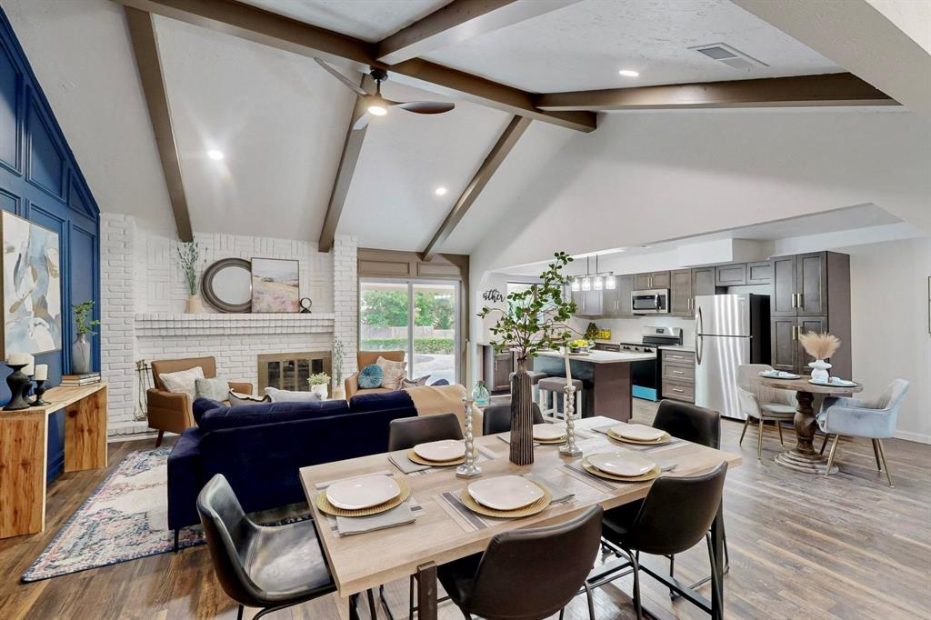 3965 Singleleaf Lane Fort Worth, TX 76133 - Photo 2 of 39 Open-concept living space featuring vaulted ceilings with exposed beams, wood-finish flooring, and a white brick fireplace