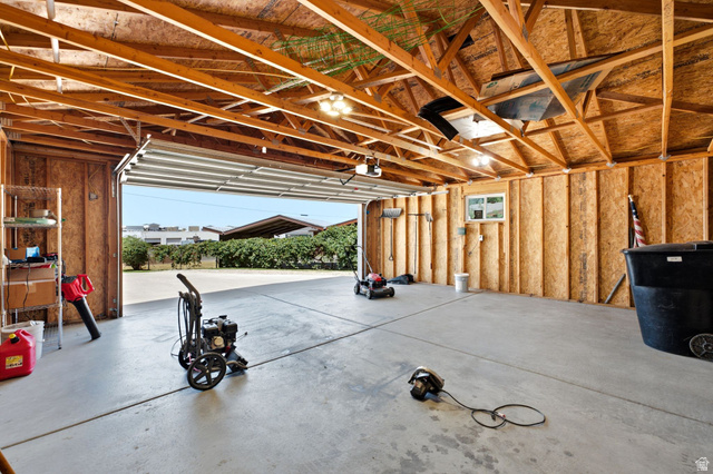 1925 South Main Street Bountiful, UT 84010 - Photo 30 of 48 Spacious garage featuring exposed wood beam ceiling, concrete flooring, a single window, and an overhead door