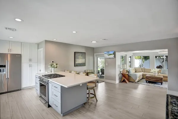 a large white kitchen with sink and refrigerator