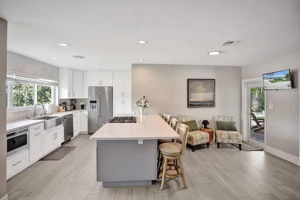 a kitchen with kitchen island a stove a table and chairs