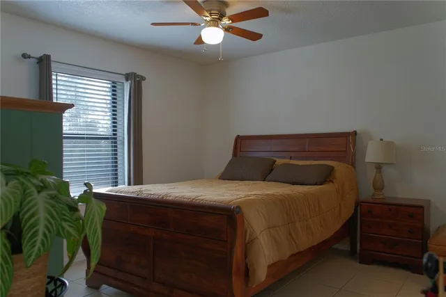 a bedroom with a bed and a potted plant
