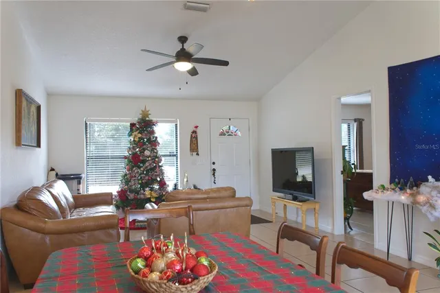 a living room with furniture a flat screen tv and a chandelier