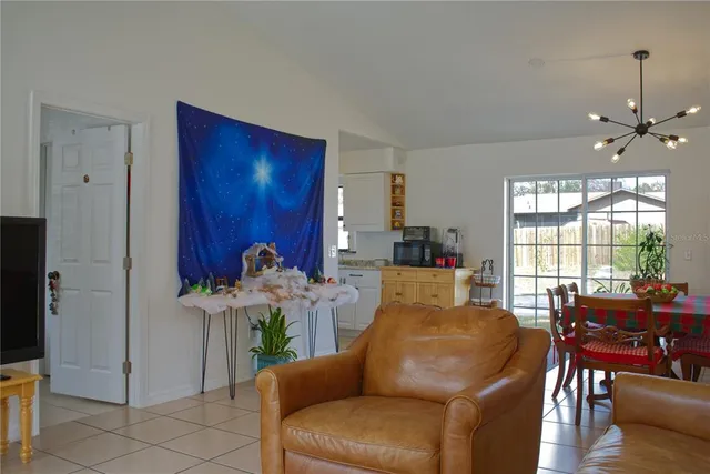 a living room with furniture a chandelier and a dining table