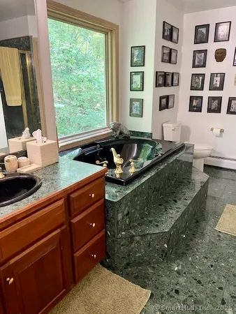 a kitchen with stainless steel appliances granite countertop a sink a stove and a wooden floor