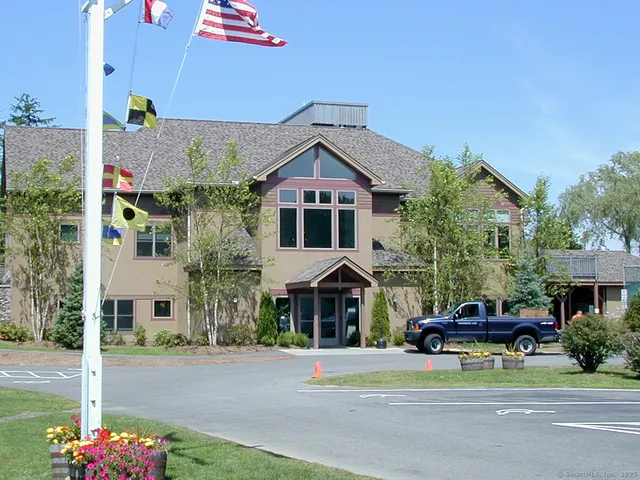 a view of a roof deck with table and chairs a barbeque with wooden floor and fence