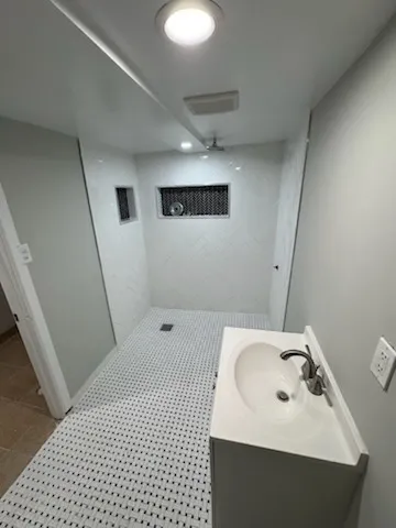 a bathroom with a sink a toilet and shower