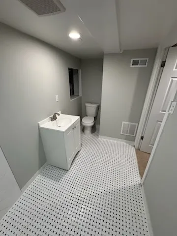 a bathroom with a sink a toilet and a mirror