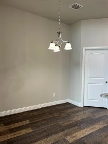 a view of a room with wooden floor and ceiling fan