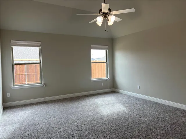an empty room with a window and a fan