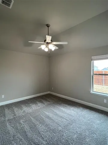 an empty room with a chandelier fan