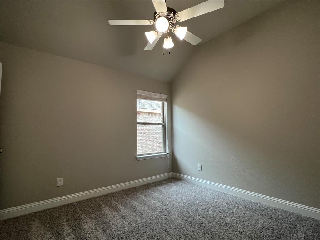 277 Eagle Ridge Forney, TX 75126 - Photo 17 of 19 Carpeted empty room with vaulted ceiling and ceiling fan
