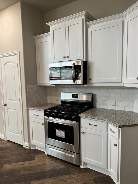 277 Eagle Ridge Forney, TX 75126 - Photo 6 of 19 Kitchen featuring gas range oven, white cabinets, tasteful backsplash, stainless steel microwave, and light stone counters