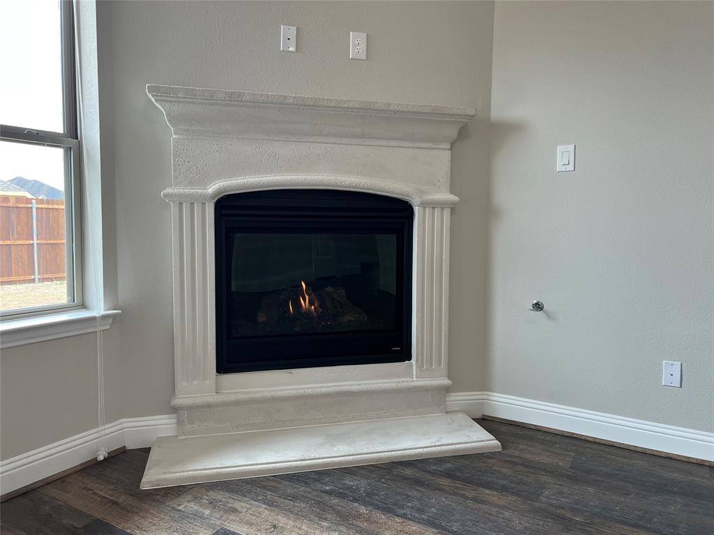 277 Eagle Ridge Forney, TX 75126 - Photo 7 of 19 Detailed view of wood finished floors and a warm lit fireplace