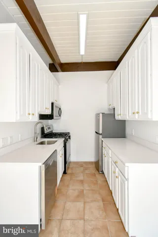 a kitchen with stainless steel appliances a sink a stove and cabinets