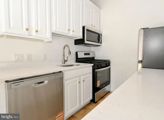 a kitchen with white cabinets and white appliances