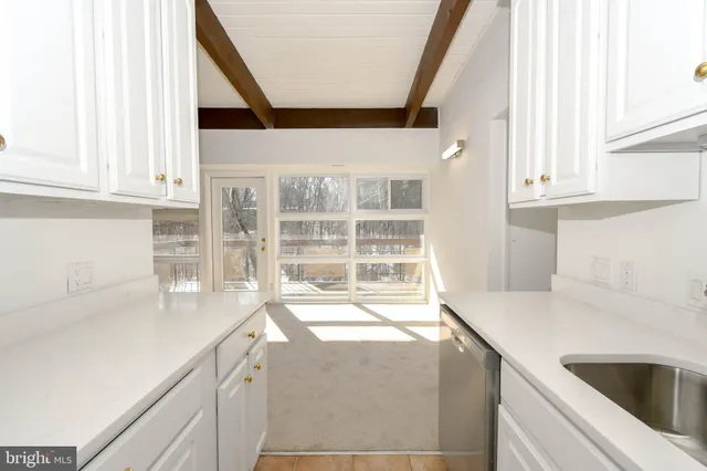 a view of a kitchen with granite countertop a sink and a window