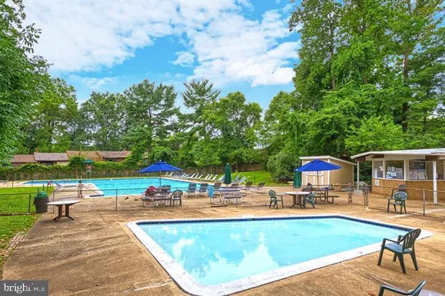 swimming pool view with a seating space and a garden view