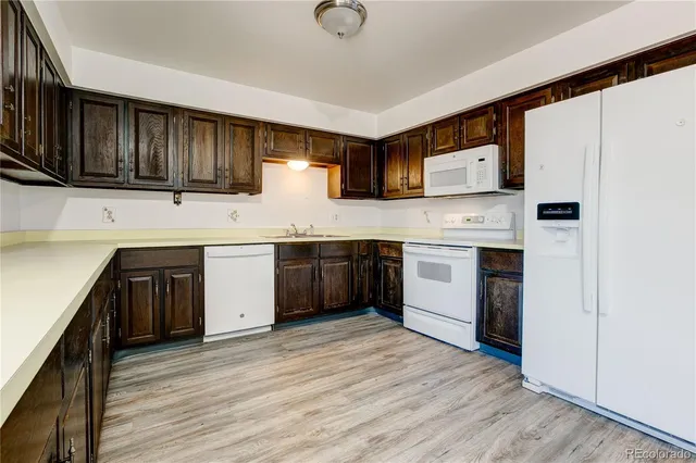a kitchen with a sink cabinets and wooden floor