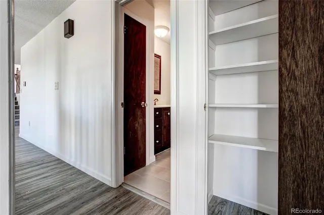 a view of a hallway with wooden floor and closet