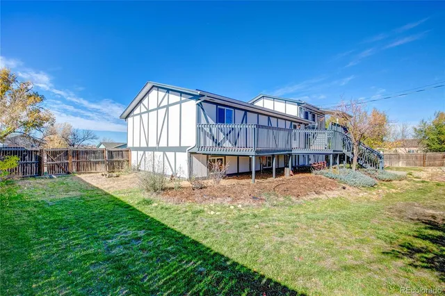 a view of a house with a big yard and large trees