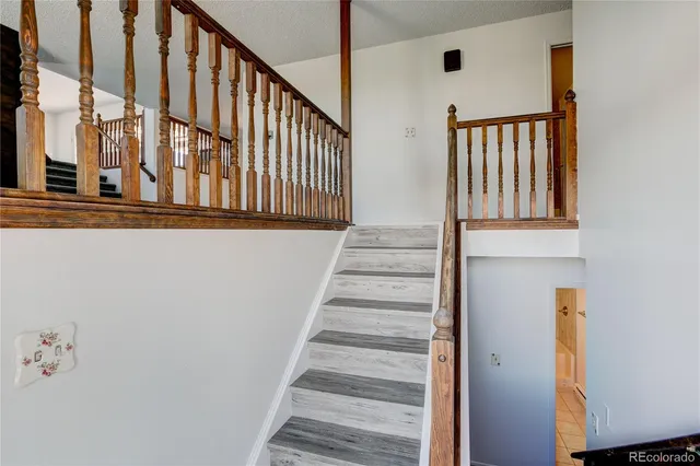 a view of staircase with lots of frames on wall and a window