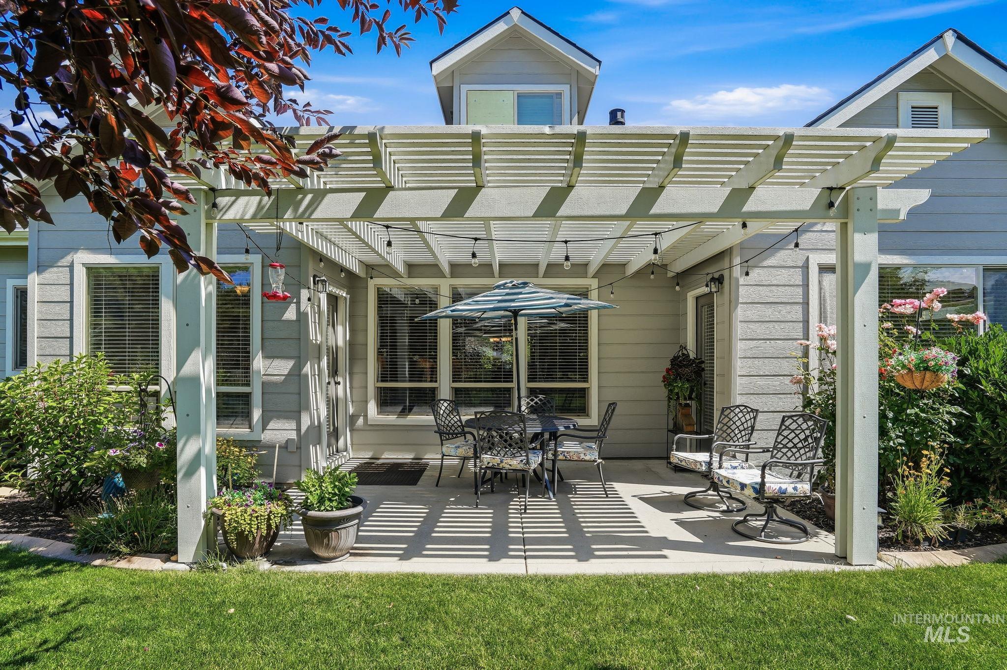 3969 North Hollymount Way Meridian, ID 83646 - Photo 42 of 47 Backyard patio featuring a white pergola with string lighting, concrete flooring, and surrounding green lawn