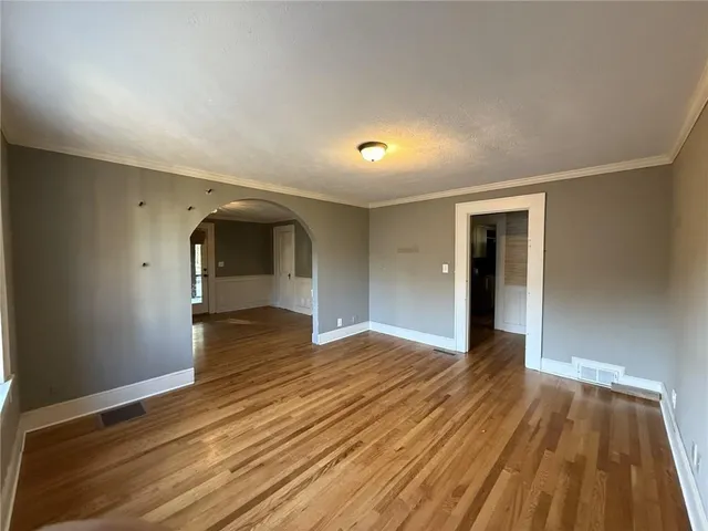 a view of empty room with wooden floor