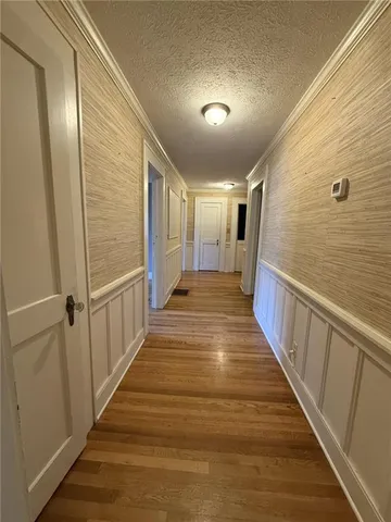 a view of a refrigerator in kitchen and an empty room