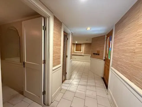 a view of a refrigerator in kitchen and an empty room