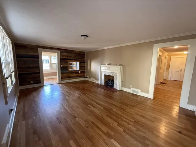 an empty room with wooden floor and fireplace