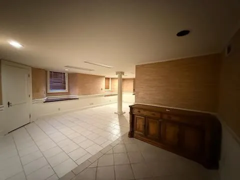 a view of an empty room with glass door and wooden floor