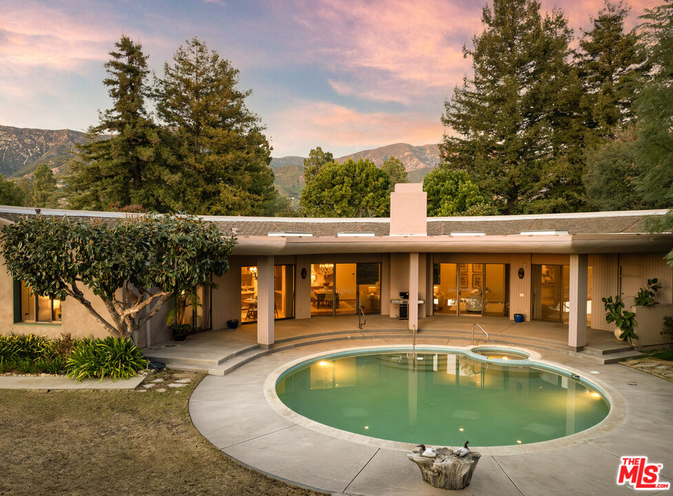 an outdoor swimming pool with outdoor seating and yard