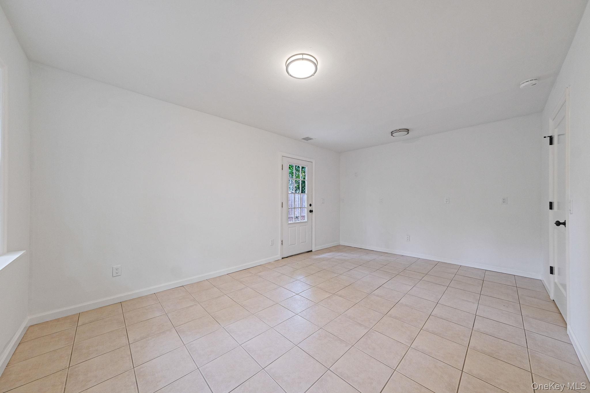 11 Wildwood Road Ridge, NY 11961 - Photo 12 of 17 Spare room featuring light tile patterned floors and baseboards