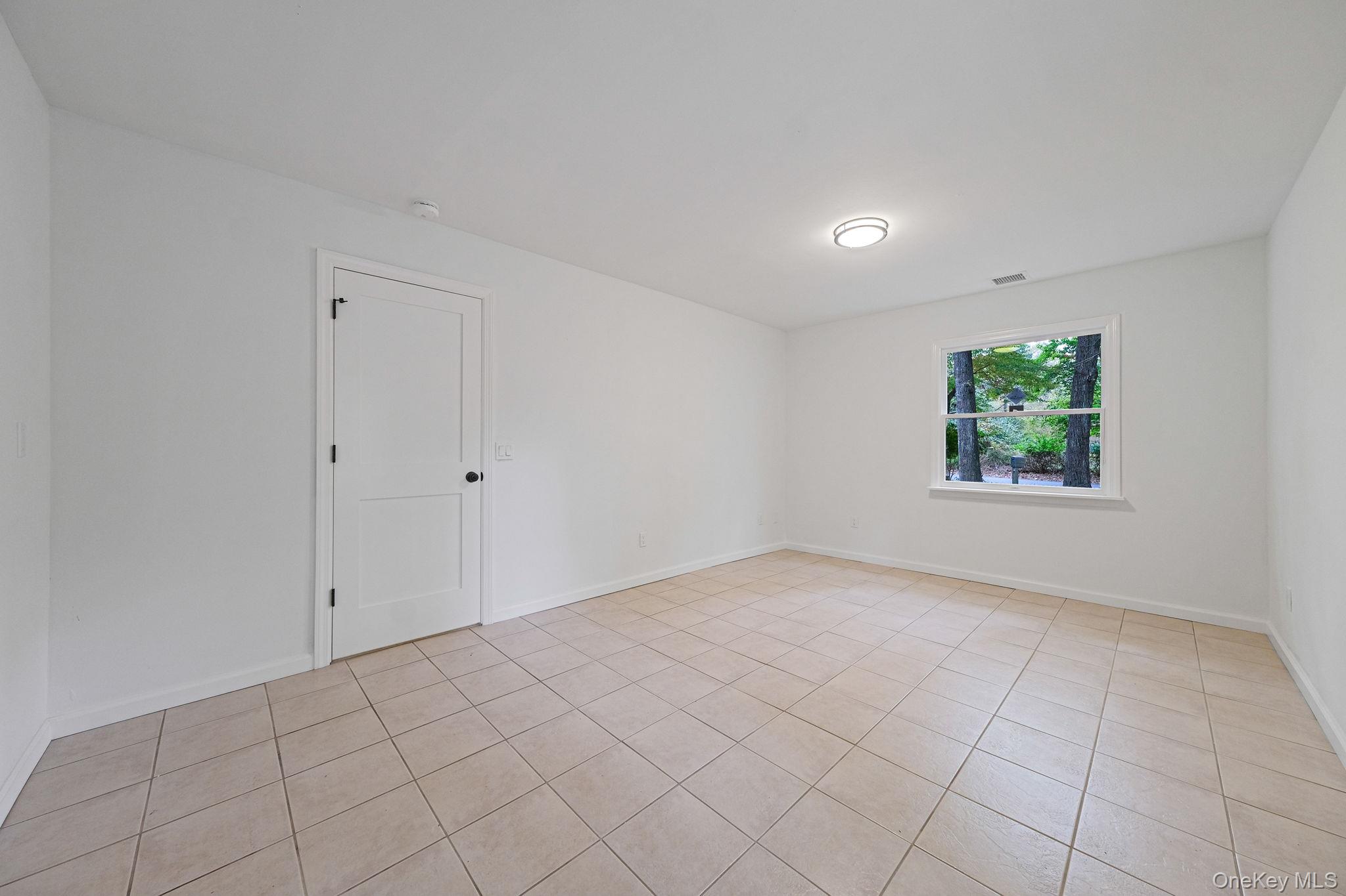 11 Wildwood Road Ridge, NY 11961 - Photo 14 of 17 Spare room featuring light tile patterned floors