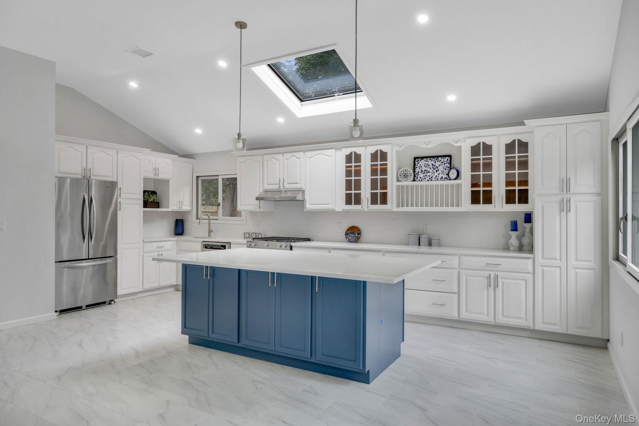 11 Wildwood Road Ridge, NY 11961 - Photo 4 of 17 Kitchen with pendant lighting, blue cabinets, freestanding refrigerator, a skylight, and white cabinets