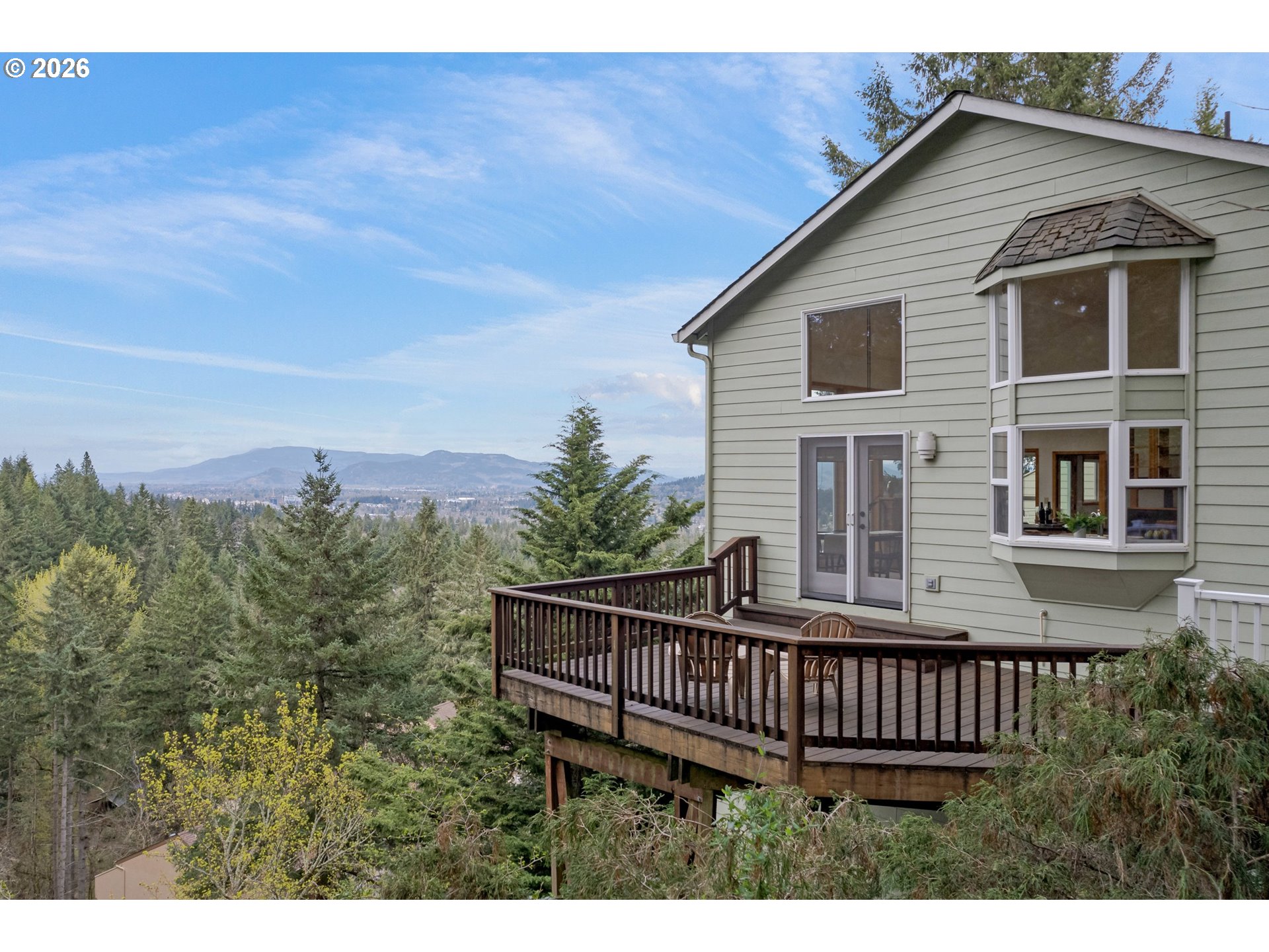 a view of a house with wooden deck and furniture
