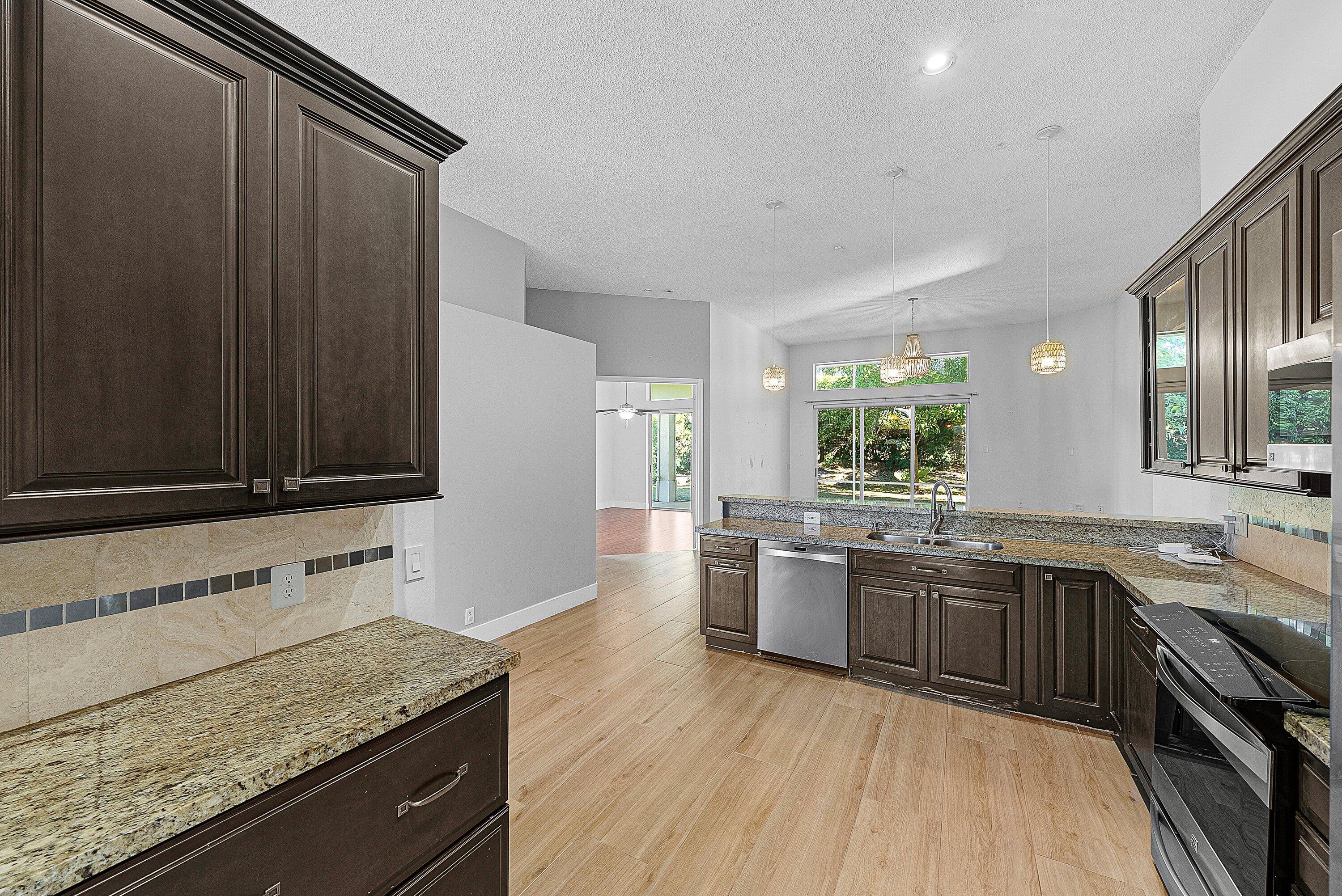 19712 Dinner Key Drive Boca Raton, FL 33498 - Photo 12 of 28 a kitchen with lots of counter top space and wooden floor