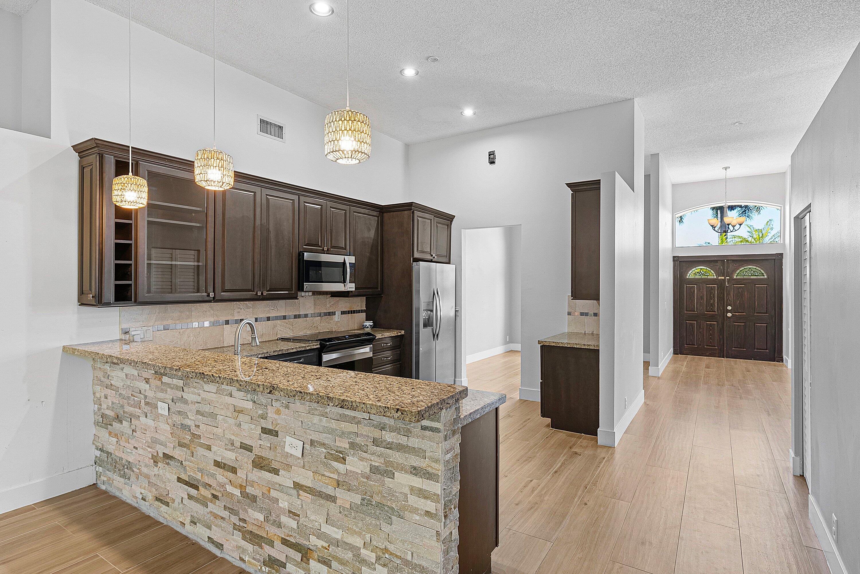 19712 Dinner Key Drive Boca Raton, FL 33498 - Photo 15 of 28 a kitchen with granite countertop a refrigerator and a sink