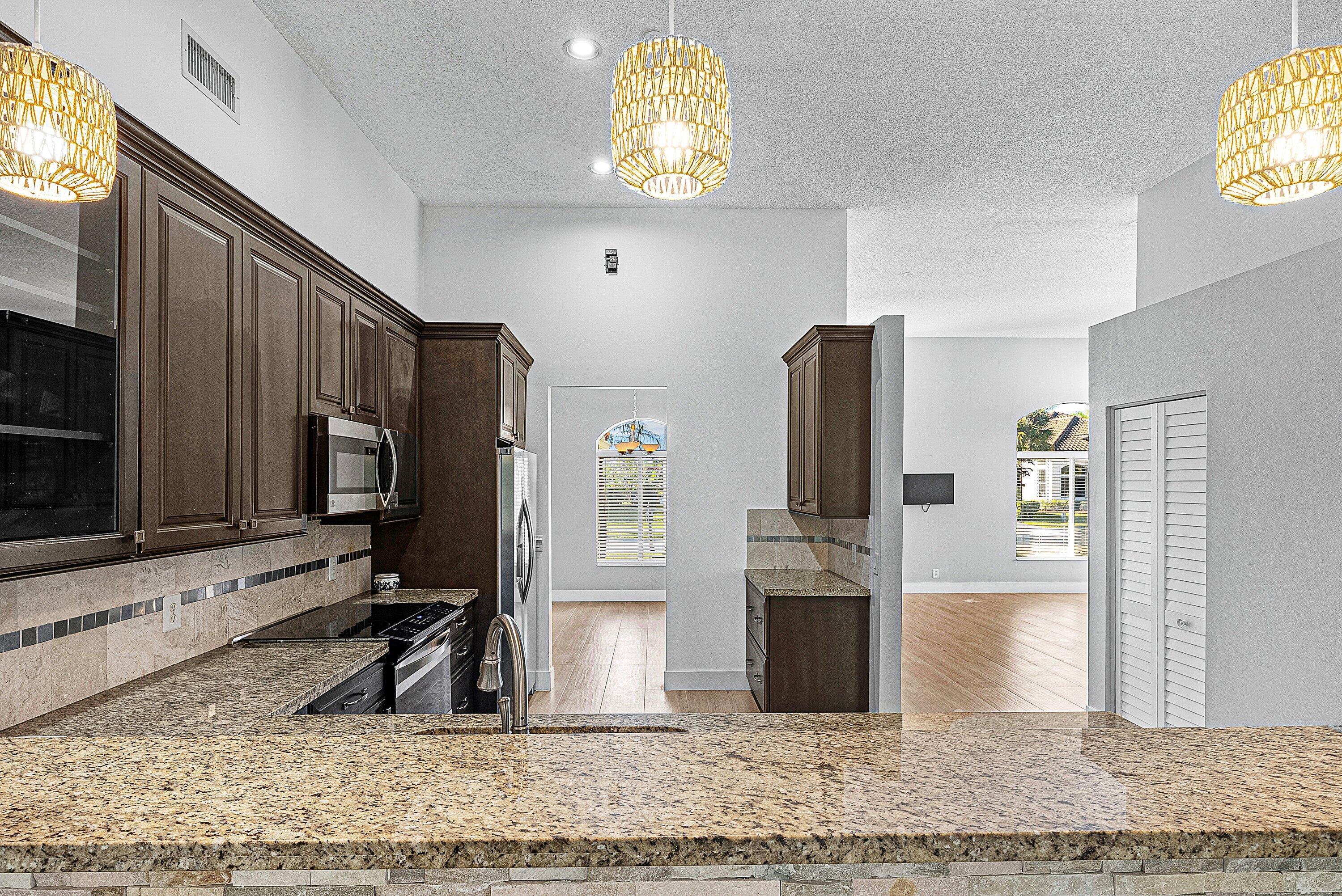 19712 Dinner Key Drive Boca Raton, FL 33498 - Photo 16 of 28 a view of a kitchen with microwave and furniture