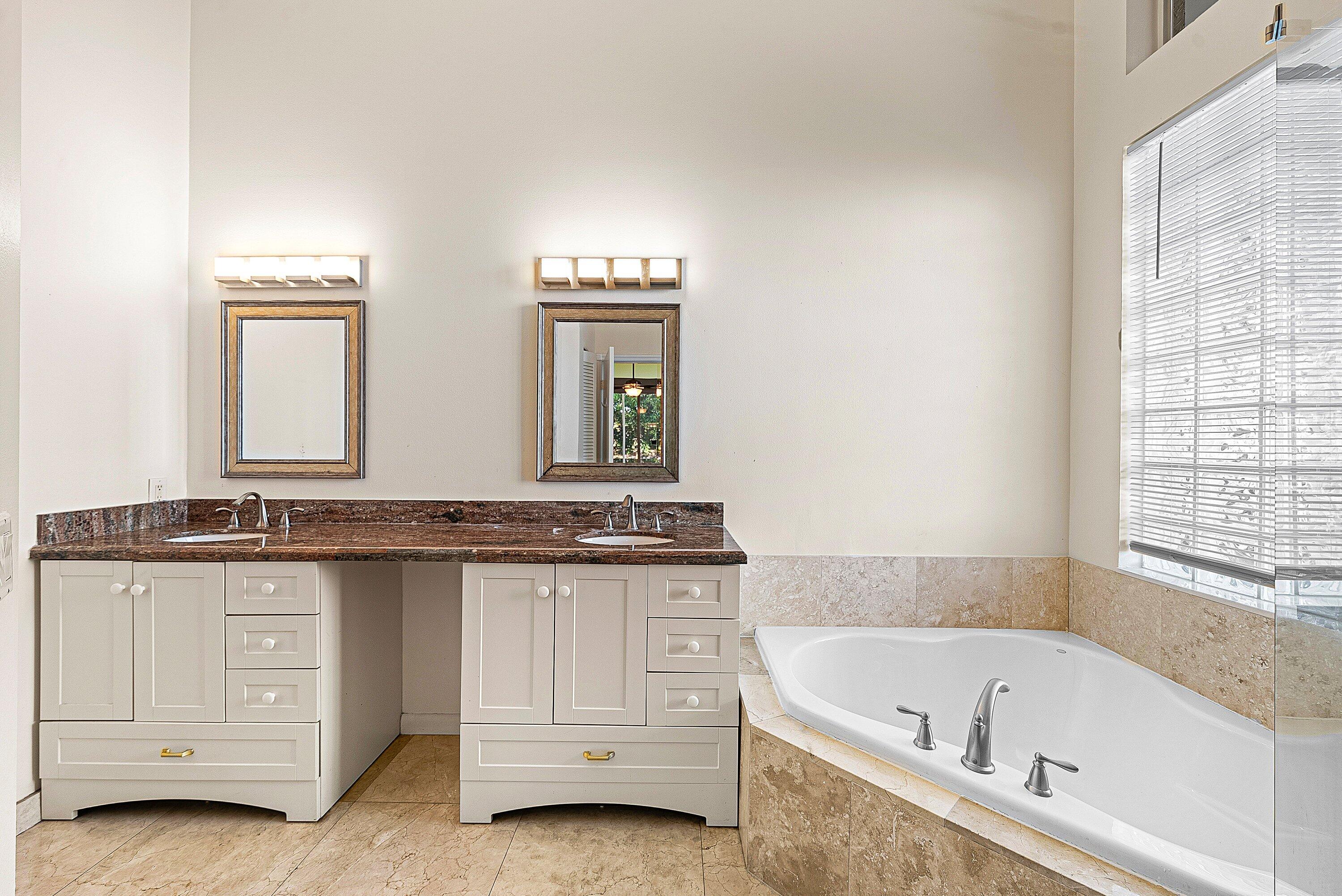 19712 Dinner Key Drive Boca Raton, FL 33498 - Photo 19 of 28 a bathroom with a granite countertop bathtub a sink and a large mirror