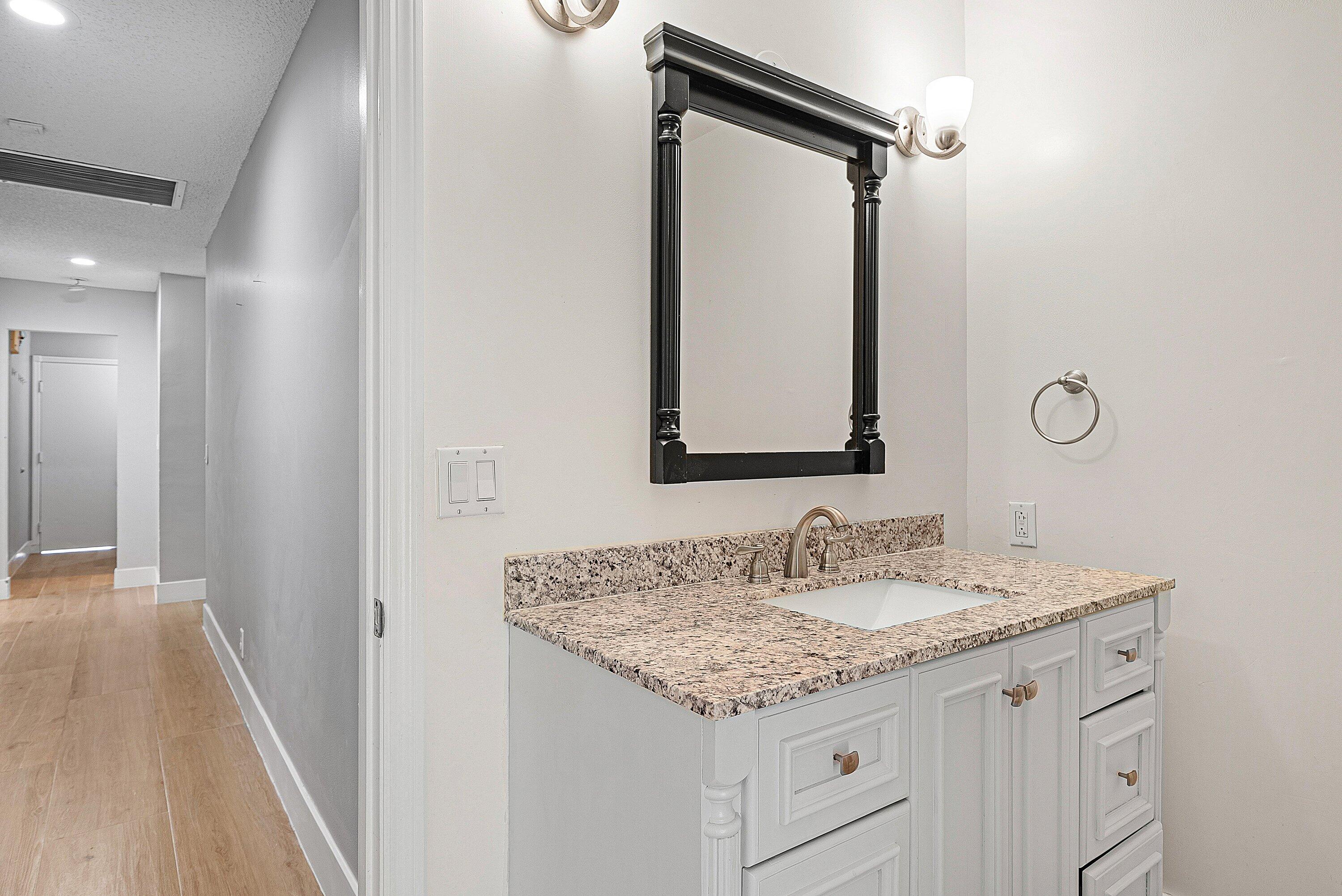 19712 Dinner Key Drive Boca Raton, FL 33498 - Photo 22 of 28 a bathroom with a granite countertop sink and a mirror