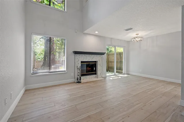 wooden floor fireplace and windows in an empty room