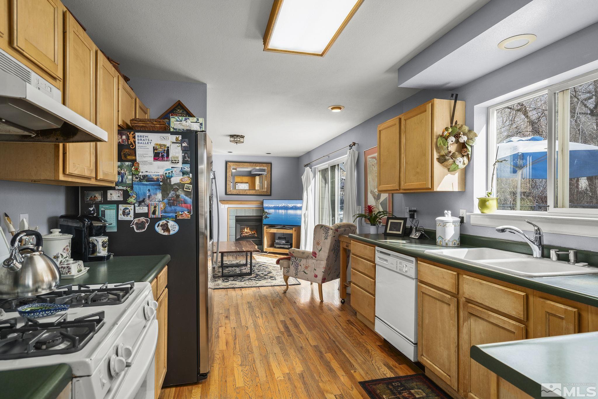 3160 Knight Road Reno, NV 89509 - Photo 8 of 39 a kitchen with stainless steel appliances a stove a sink dishwasher and cabinets with wooden floor