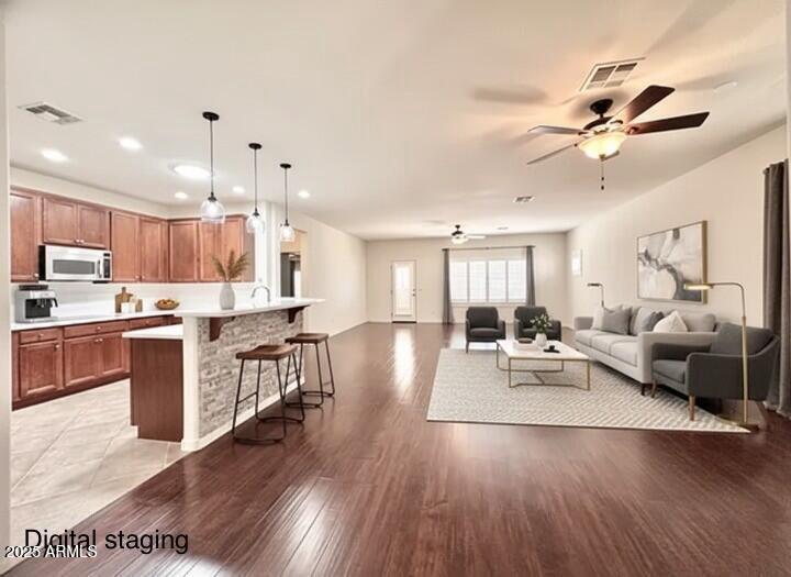 a living room with stainless steel appliances kitchen island granite countertop wooden floor a dining table and chairs