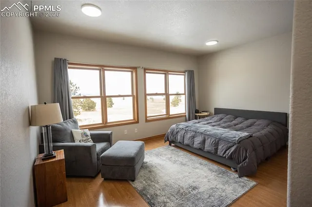 a bedroom with a bed and a couch with windows