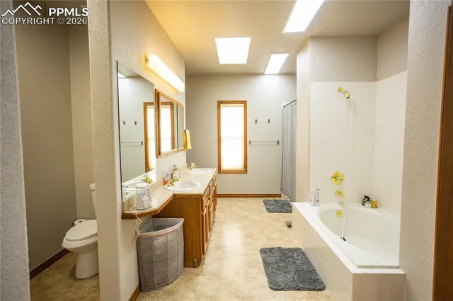 a spacious bathroom with a tub sink and toilet