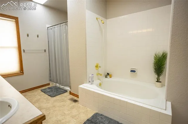 a bathroom with a tub sink and shower