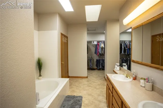 a bathroom with a tub sink and mirror
