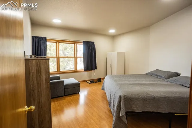 a bed sitting in a spacious bedroom next to a window
