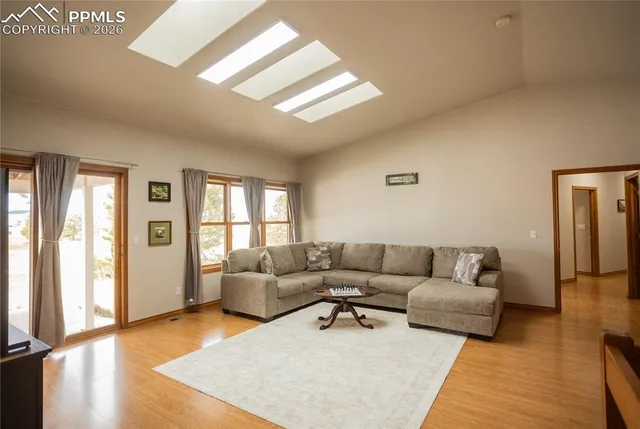 a living room with furniture wooden floor and a large window